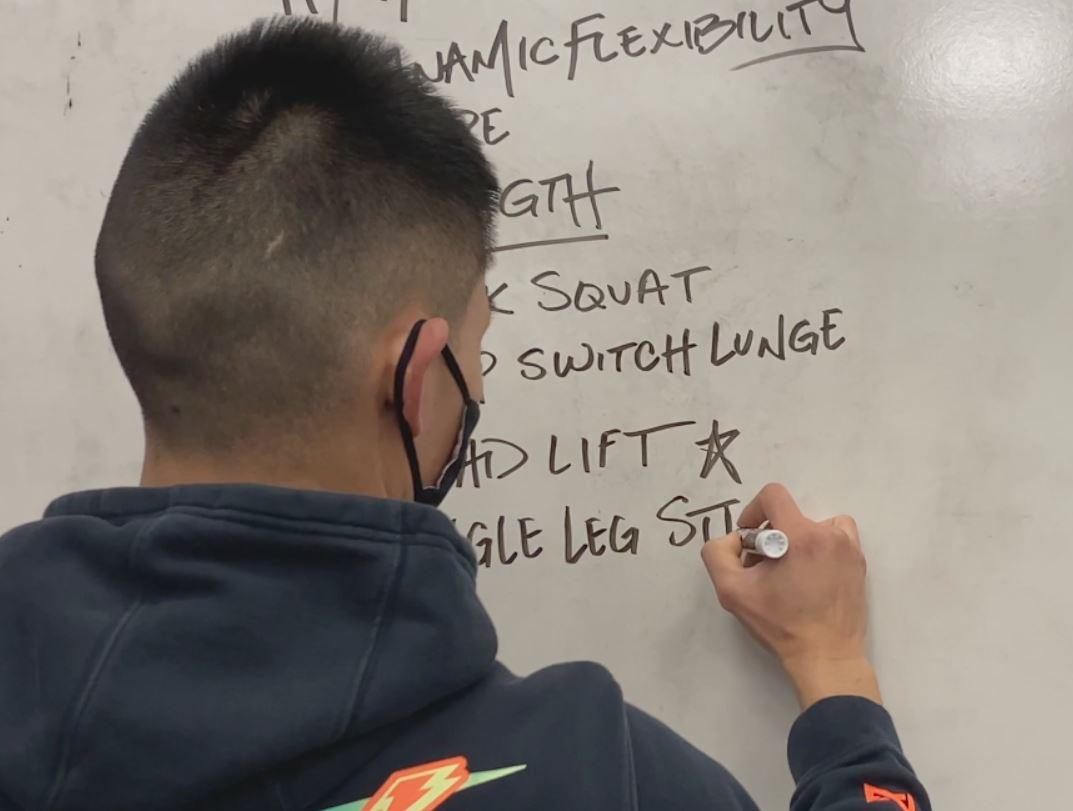 Coach writing on whiteboard goals for the session