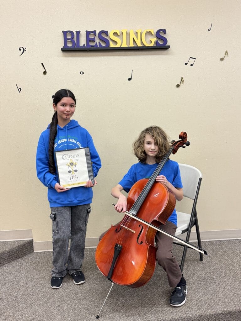 OMEA student musicians pose with choir folder and cello